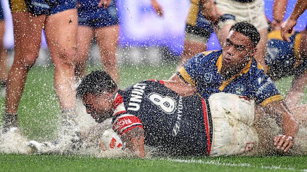 Wet and wild: Spencer Leniu scores for the Roosters againt Parramatta on Friday.
