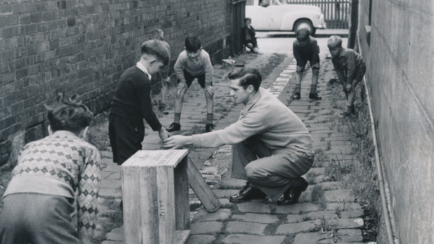 Humble beginnings: Neil Harvey gives a few tips to boys playing cricket in the lane beside the Harvey home in North Fitzroy in 1950.