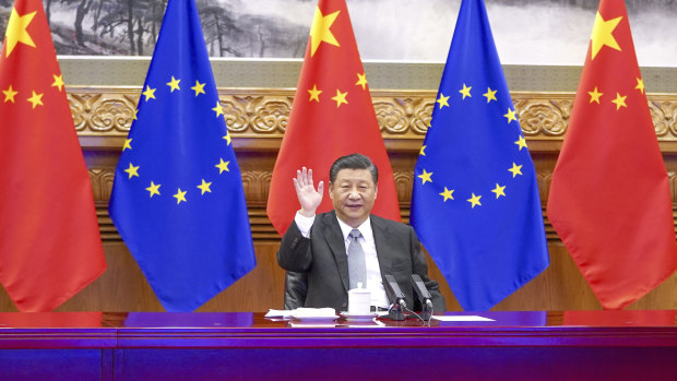 Chinese President Xi Jinping waves during a video conference with European leaders.