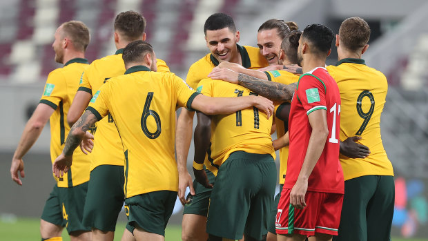 Plenty to smile about ... Socceroos players celebrate Awer Mabil’s (11) goal against Oman.