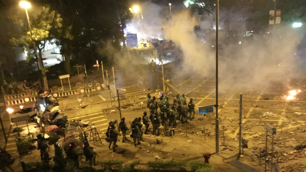 Riot police storm road in front of Polytechnic University before dawn. 