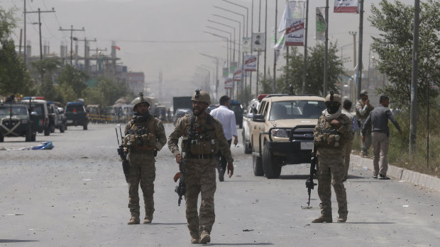 Afghan security men stand guard after the explosion near the police headquarters in Kabul, Afghanistan. The Taliban has claimed responsibility for the bombing. 