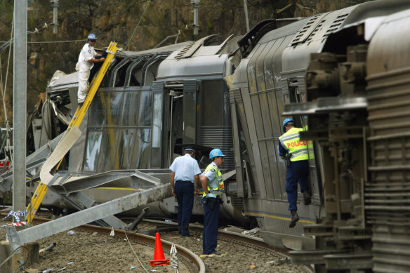 Police and emergency service workers at the crash scene south of Waterfall station on January 31, 2003.