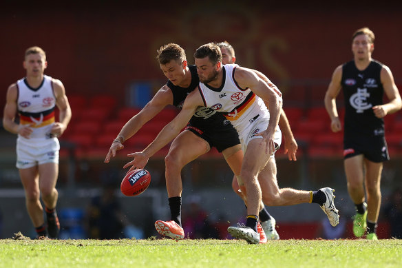 Patrick Cripps, left, and Brad Crouch, right, compete for the ball at Metricon Stadium. 