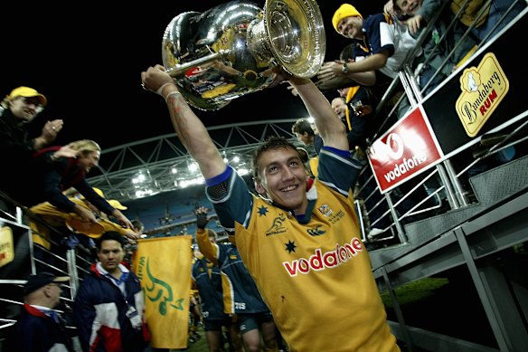 Mat Rogers holds the Bledisloe Cup aloft in 2002.