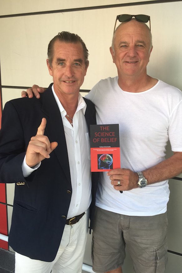 Bradley Charles Stubbs poses with his first book, The Science of Belief with Socceroos coach Graham Arnold.