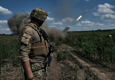 A Ukrainian soldier watches a Grad multiple launch rocket system firing shells with flyers near Bakhmut, Donetsk region.