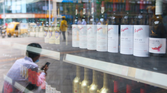 A man sits in front of a wine shop tht sells Australian wines in eastern Beijing’s Tongzhou district. 