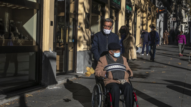 People wear face masks to prevent the spread of coronavirus in downtown Madrid, Spain.