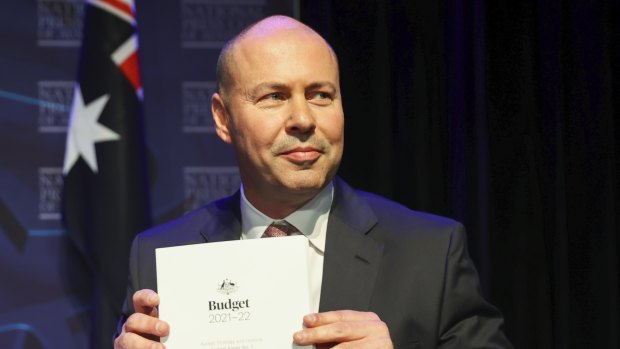 Treasurer Josh Frydenberg poses for photos with the budget papers before delivering his post-budget address to the National Press Club.