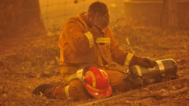 A fireman takes a breather as the the bushfire rages towards the townships of Labertouche and Tonimbuk. 