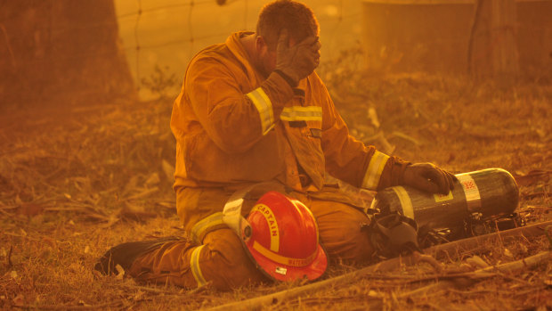 A fireman takes a breather as a bushfire rages towards the eastern Victorian townships of Labertouche and Tonimbuk on Black Saturday, February 7, 2009.
