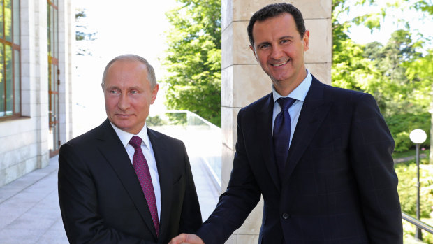 Russian President Vladimir Putin shakes hands with Syrian President Bashar al-Assad.