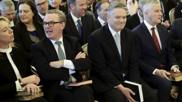 Not everyone was smiling: Turnbull supporter Christopher Pyne waits for the beginning of the ceremony beside Senator Cormann.