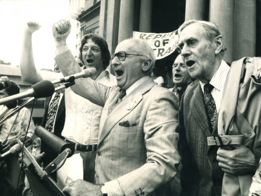 From left: Union leader John Halfpenny, writer and academic Donald Horne and author Patrick White lead the singing of Advance Australia Fair on the steps of Sydney Town Hall in 1976. They were "maintaining the rage" over the dismissal of the prime minister, Gough Whitlam, by the governor-general, John Kerr, one year earlier.