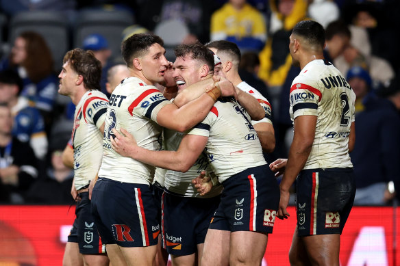 Roosters players embrace Angus Crichton.