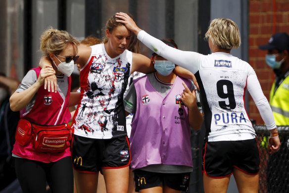 Rhiannon Watt, left, of the Saints leaves the field injured during round eight. 