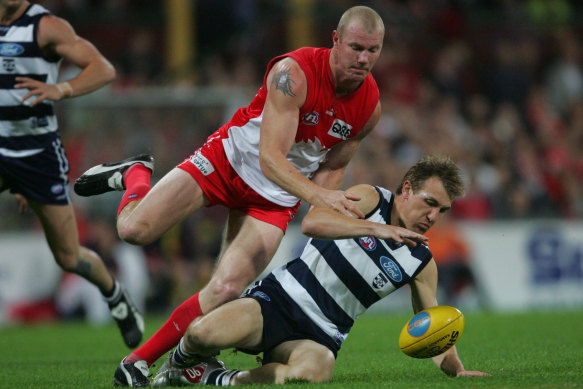 Barry Hall chases down a Geelong player.