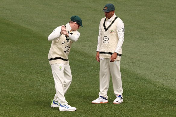 Steve Smith of Australia mimics a golf shot as he talks with Usman Khawaja of Australia.