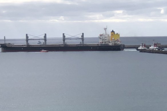 Tugboats haul on lines affixed to the grain carrier MV Medi Portland, stuck at the entrance to Portland’s harbour.