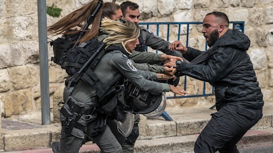 Members of the Israeli security forces scuffle with a Palestinian man at a checkpoint near Lion’s Gate to enter the Al-Aqsa Mosque compound before the Friday noon prayer in Jerusalem.