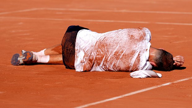 Jakub Mensik collapses after his four-set victory in almost five hours of heat.