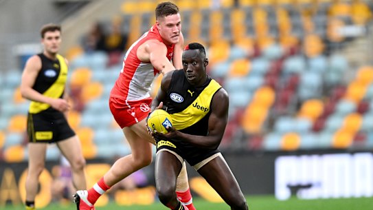 Crouching Tiger: Mabior Chol breaks through the Swans defence during the round 6 clash at The Gabba in Brisbane.