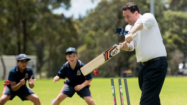 Four more: NSW Sports Minister Stuart Ayres plays a game of cricket with kids at the NSW Cricket HQ announcement.