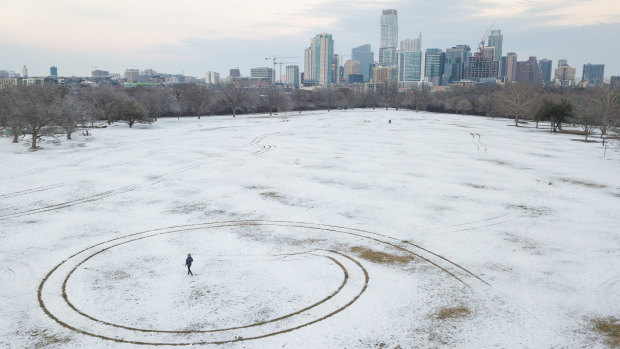 A person walks through a snow covered Zilker Park in Austin, Texas.