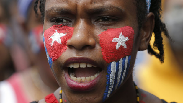 A Papuan student with her face painted with the colours of the separatist 'Morning Star' flag shouts slogans during a rally near the presidential palace in Jakarta, Indonesia.
