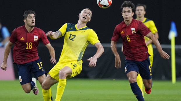 Australia’s Mitch Duke, center, controls the ball as Spain’s Oscar Gil, left, and Martin Zubimendi give chase.