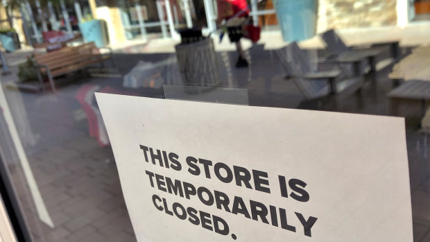 A closed sign hangs in the door of a Converse shoe store on Monday.