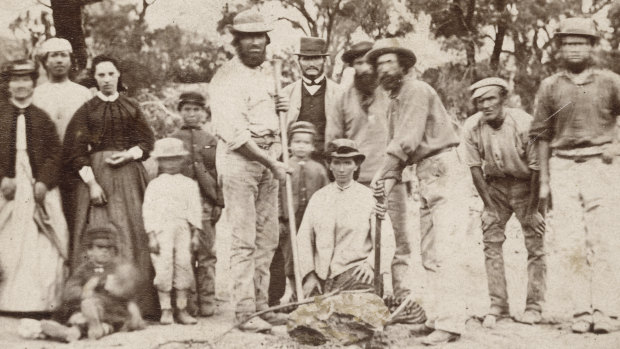 Prospectors John Deason (left with crowbar) and Richard Oates (right with pick), with family and friends. A lump of quartz stands in for the nugget.