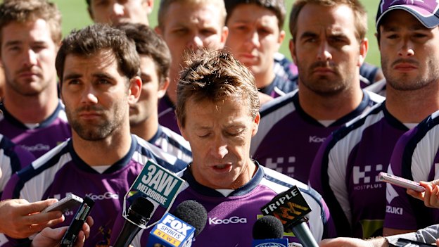 United … Surrounded by all 22 players, Melbourne Storm coach Craig Bellamy reads a statement to the media in 2010 during the salary cap scandal.