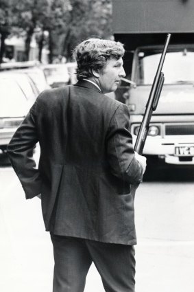 A detective checks vehicles leaving the RMIT car park behind the Russell Street courts after Ray Chuck was gunned down.