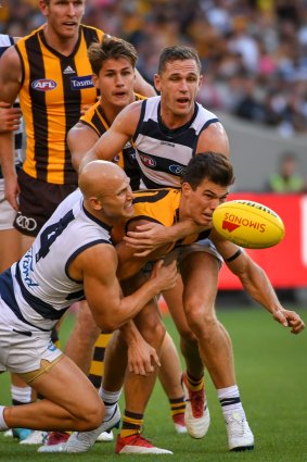 Jaeger O'Meara is tackled by Geelong pair Gary Ablett and Joel Selwood.