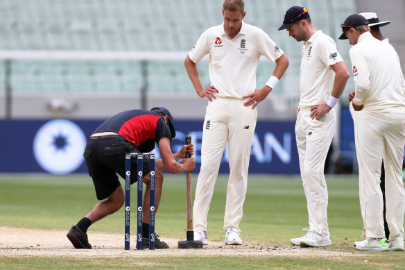 Players watch on as a groundsman attempts to flatten out the pitch on day five of the Boxing Day Test in 2017.