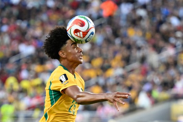 Australia’s Lucas Herrington (25) heads the ball.