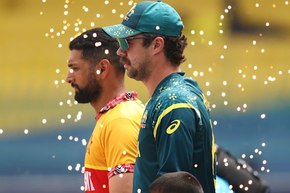 Sikandar Raza of Zimbabwe and Travis Head of Australia lead out their sides.
