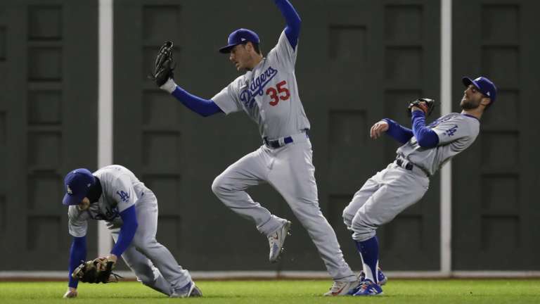 Playing the percentages: Three LA Dodgers raffle a catch in the outfield.