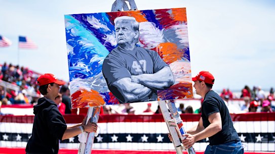 Masculinity pitch: Workers move a portrait of former president Donald Trump by the artist Scott LoBaido at a rally in Wildwood Beach, New Jersey.