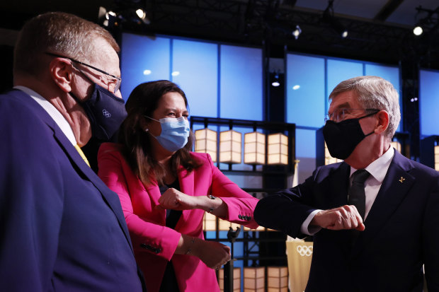 The president of the International Olympic Committee, Thomas Bach, right, bumps elbows with Premier Annastacia Palaszczuk and John Coates. 