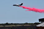 A tanker aircraft dumps fire retardant on a field southwest of Salado, Texas, after a military helicopter crashed and sparked a grass fire.