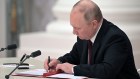 Vladimir Putin signs a document on Monday recognising the independence of two breakaway Ukrainian territories.