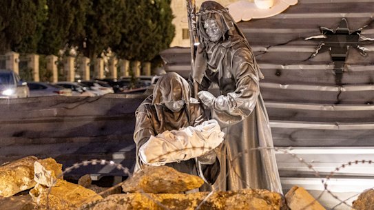 An art work called Nativity Under the Rubble by Palestinian artist Tariq Salsa is photographed in Manger Square near the Church of Nativity in Bethlehem in the West Bank. In the place of baby Jesus, the art work shows a child surrounded by rubble.