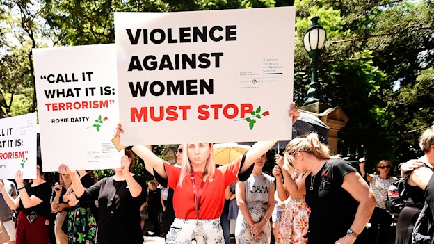 Protesters hold placards during a domestic violence protest organised by the Red Rose Foundation in Brisbane on Friday.