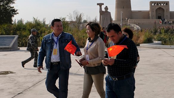Chinese national flags on the hands of minorities who are on a patriotic tour to Ermin Minaret in Turpan City, Xinjiang Uyghur Autonomous Region, China last month.