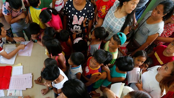 Children and their parents arrive at a health centre in February, in Manila, Philippines, to have their children vaccinated following an outbreak of measles.
