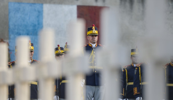 Romanian soldiers in Bucharest stand at attention next to graves of French soldiers killed in Romania during WWI.