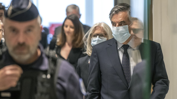 Francois Fillon, right, and his wife Penelope wear protective masks as they arrive at Paris courthouse on Monday.